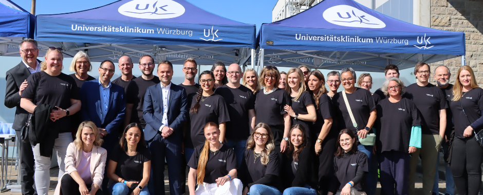 Das Projektteam aus der UKW-Pflege steht im aufgereiht im Freien und lächelt in die Kamera