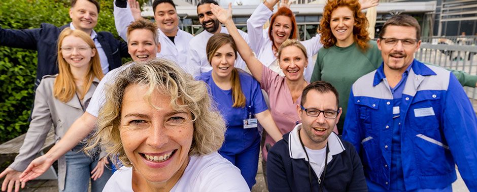 Illustrationsbild Karriere am UKW: ein Gruppenfoto mit Menschen in unterschiedlicher Berufskleidung