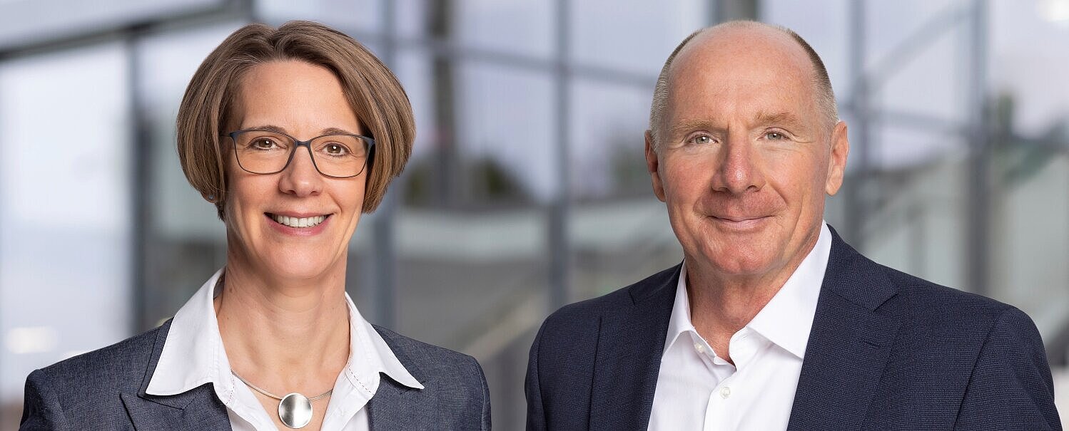 Porträt von Valerie Orth und Bernhard Nieswandt - beide tragen ein helles Hemd bzw. Bluse und ein dunkles Jacket bzw. Blazer.