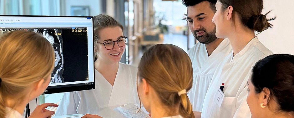 Pflegeazubis und Medizinstudierende sprechen an einem Visitenwagen