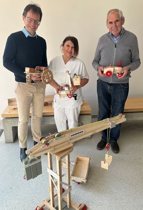 Bei der Übergabe der Holzspielzeuge (von links): Prof. Dr. Christoph Härtel, Direktor der Würzburger Universitäts-Kinderklinik, die Pflegekraft Asli Brendel sowie der Hersteller und Spender Max Steinhart.