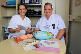 Astrid Englert und Romy Liebers präsentieren in ihrem Büro Infomaterial, Prothesen und Kissen. 