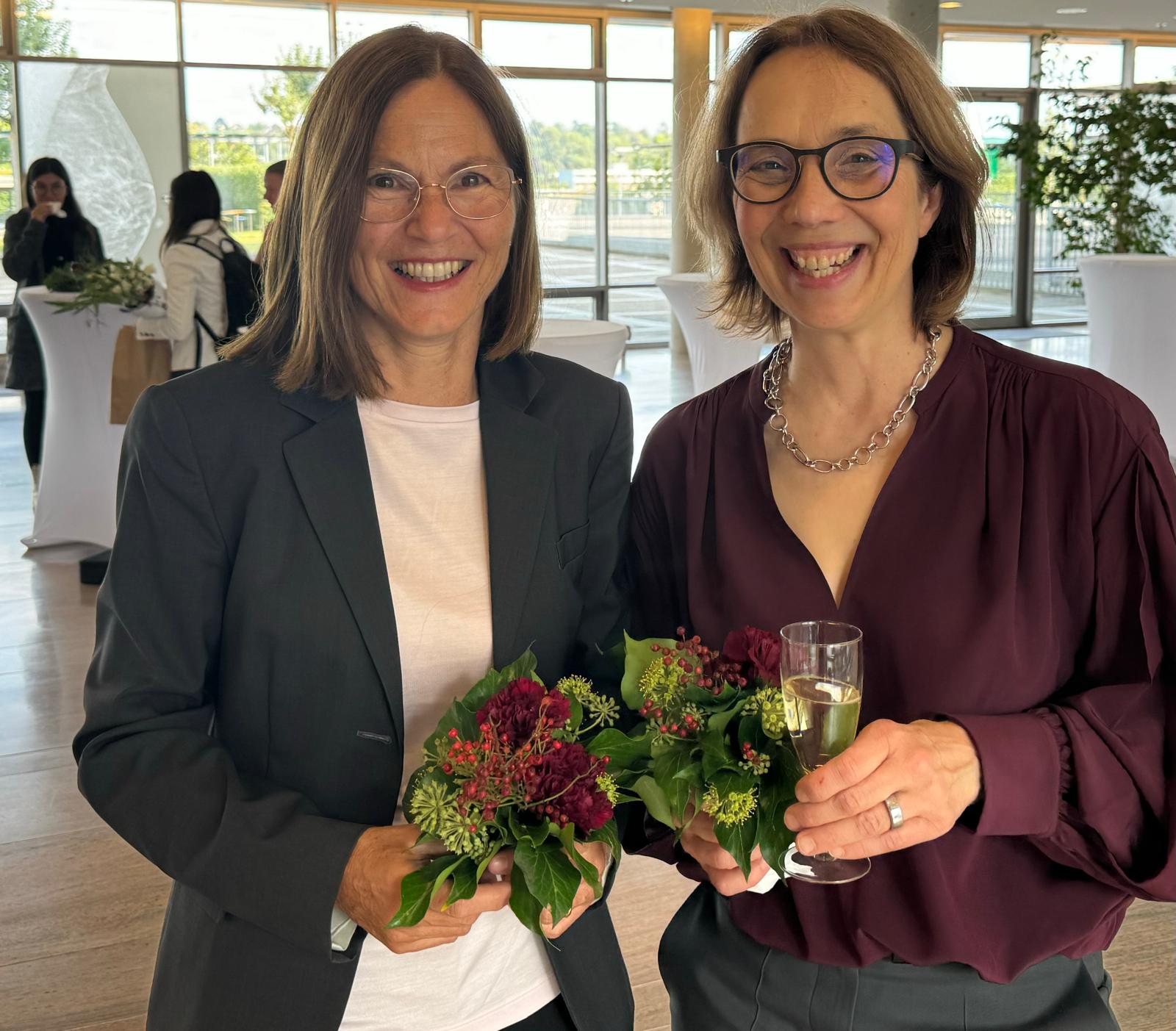 Claudia Sommer und Heike Rittner Das Bild zeigt Claudia Sommer und Heike Rittner freudestrahlend nach der Begutachtung, mit Blumen und Sektglas in den Händen.